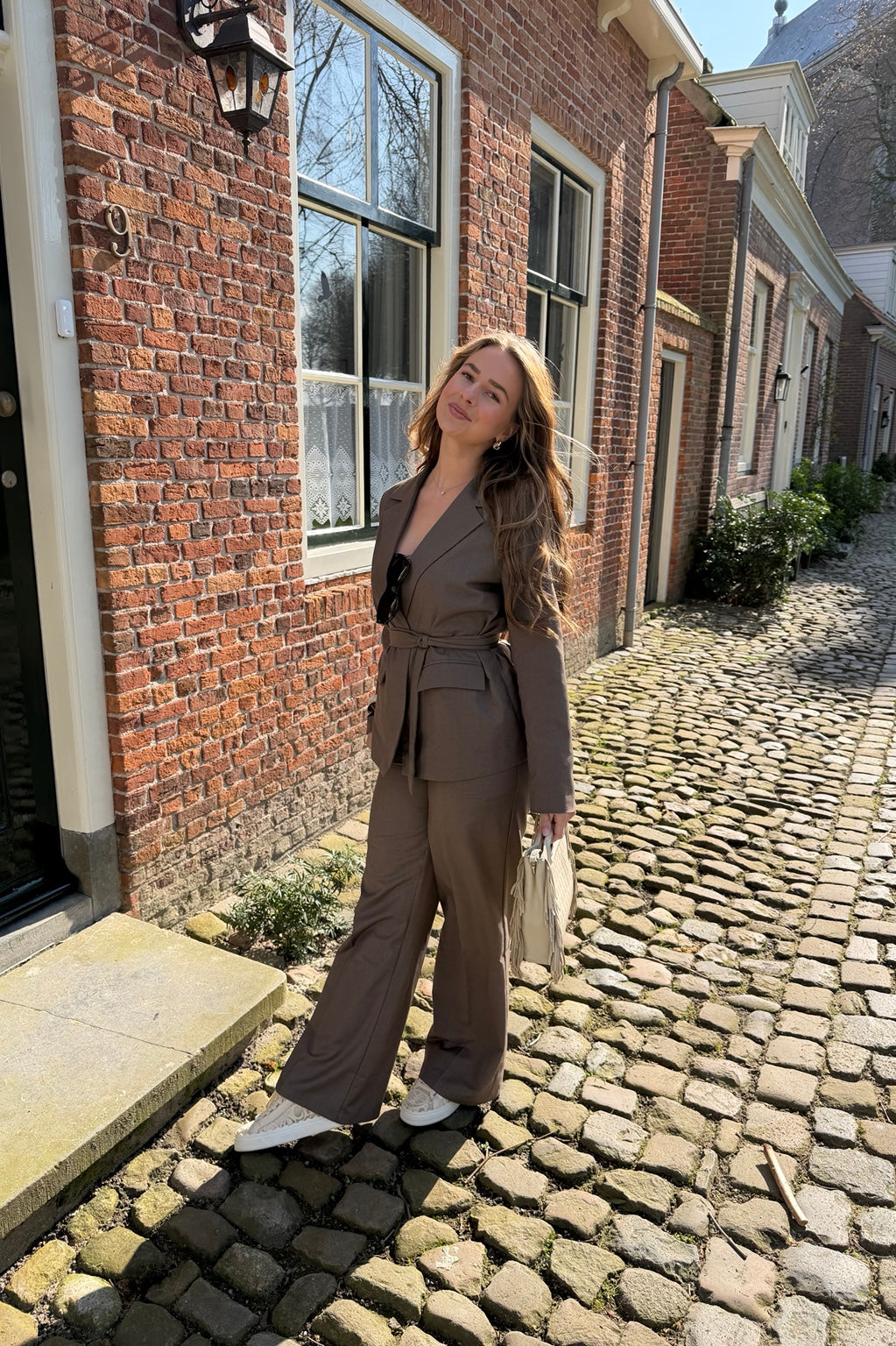 Elegance Set in taupe met getailleerde blazer en pantalon op een zonnige straat