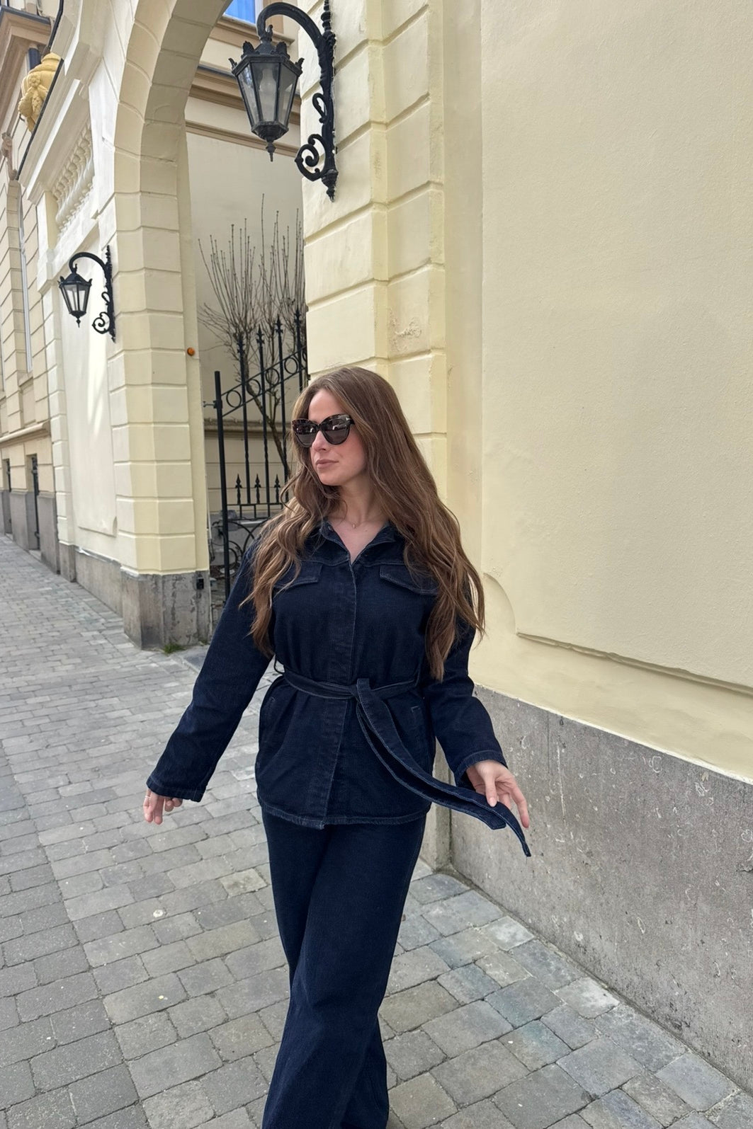 Modern Denim Set in donkerblauw denim met strikceintuur, gedragen met zonnebril