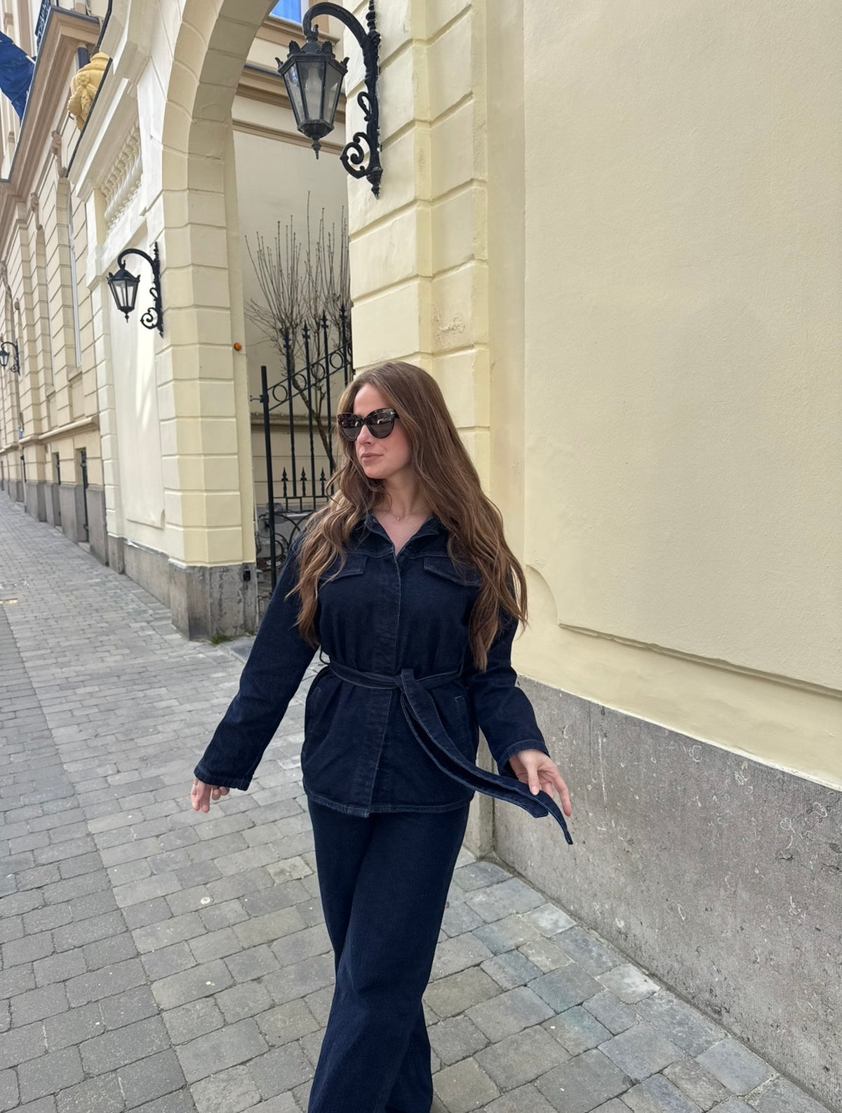 Modern Denim Set in donkerblauw denim met strikceintuur, gedragen met zonnebril